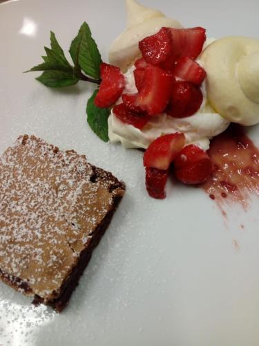 a white plate with a piece of cake and strawberries at Agriturismo La Casa Nei Boschi in Colderù
