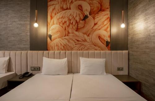 a bedroom with a bed with a painting of flamingos at La Vie Suite Hotel in Istanbul