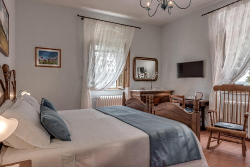 a bedroom with a bed and a desk and a television at Castellinuzza in Greve in Chianti