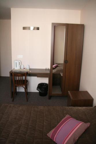 a bedroom with a bed and a desk and a mirror at Hôtel du Roussillon in Paris