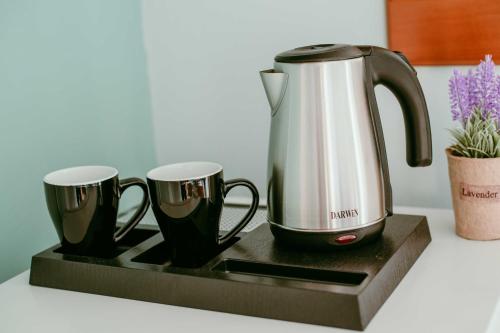 a tea kettle and two coffee cups on a tray at Island Apartments in Mesolongion