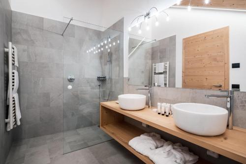 ein Bad mit 2 Waschbecken und einer Dusche in der Unterkunft Hotel Antines in Stern