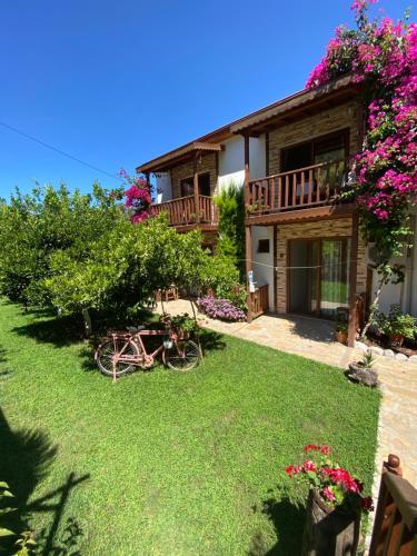 een huis met een balkon en een tuin met bloemen bij Faralya Misafir Evi in Faralya