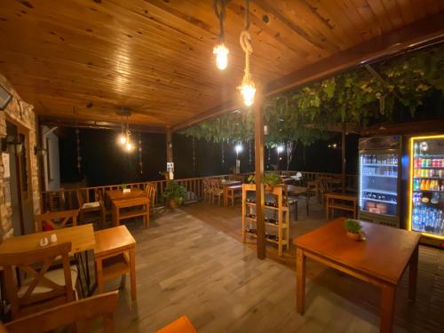 a restaurant with wooden ceilings and tables and chairs at Faralya Misafir Evi in Faralya