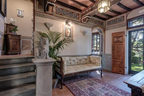 a living room with a chair and a staircase at Castellinuzza in Greve in Chianti