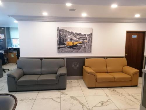 a waiting room with two couches and a picture of a train at Hotel Excelsior in Lisbon