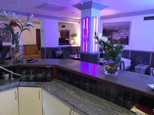 a kitchen with purple lighting and a counter with flowers on it at Hotel Excelsior in Lisbon