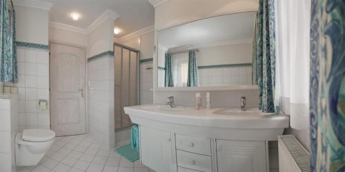 a white bathroom with a sink and a toilet at Appartement Erwin & Eleonore Hüttl - Top 1 in Neukirchen am Großvenediger