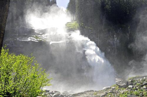 a waterfall with steam coming out of the side of a mountain at Appartement Erwin & Eleonore Hüttl - Top 1 in Neukirchen am Großvenediger