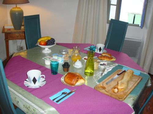 - une table avec un chiffon de table violet et des pâtisseries dans l'établissement La Maison Bleue, à Sault