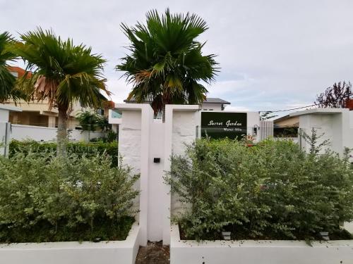 a white building with palm trees in front of it at Secret Garden Warni Villa (MUAR) in Muar