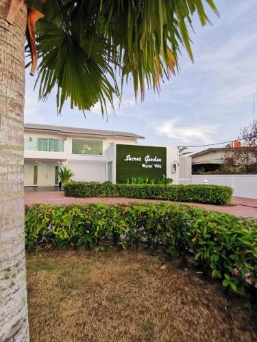 a building with a palm tree in front of it at Secret Garden Warni Villa (MUAR) in Muar