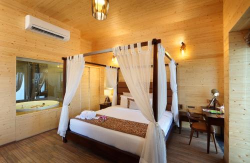 a bedroom with a bed and a tub in a room at Maliekal Heritance Cherai Beach Cochin in Cherai Beach