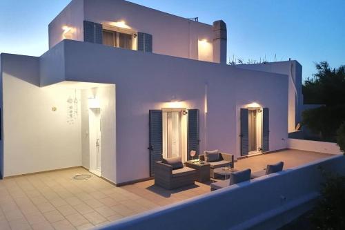 a white house with a patio with couches and chairs at RIZES ELIAS HOUSE in Isterni