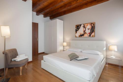 a white bedroom with a white bed and a chair at Design Palace Apartment by Wonderful Italy in Venice