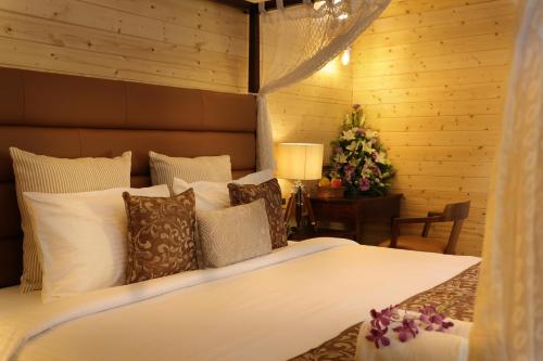 a bedroom with a large bed with white sheets and pillows at Maliekal Heritance Cherai Beach Cochin in Cherai Beach