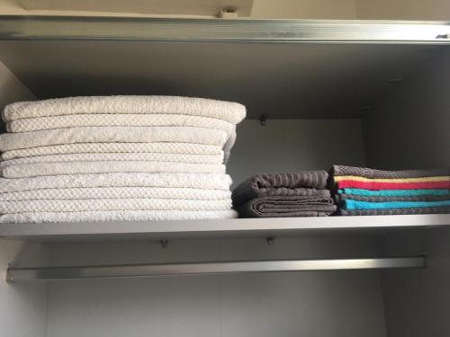 ブダペストにあるBarbara Houseの棚の上に置かれたタオルの束