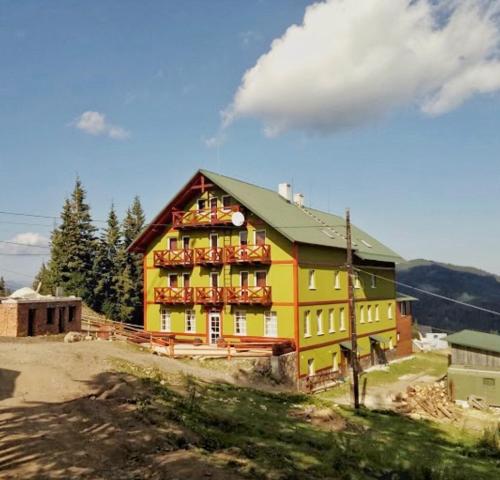 una gran casa amarilla en la cima de una colina en У-Роберта en Dragobrat