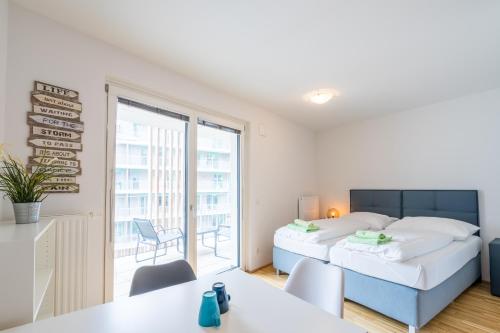 1 dormitorio con cama y ventana grande en FeelGood Apartments GreenLiving | contactless check-in, en Viena