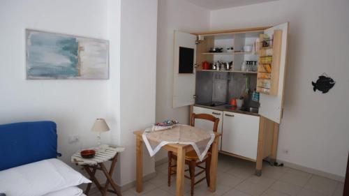 eine kleine Küche mit einem Tisch, einem kleinen Tisch und Stühlen in der Unterkunft Chez Tamara with private parking and air conditioned in Monterosso al Mare