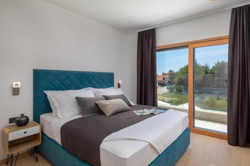 a bedroom with a large bed with a large window at VILLA DM in Vodice