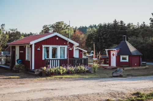 czerwony dom i mały domek z kwiatami w obiekcie Gunnagård w mieście Ullared