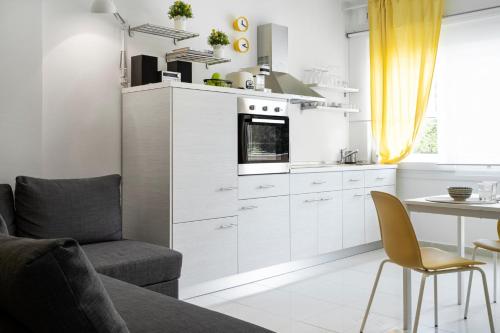 a kitchen with white cabinets and a table and a chair at Mer Epanomi in Órmos