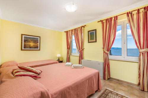 a bedroom with two beds and a window at Apartments Villa Nora in Rijeka
