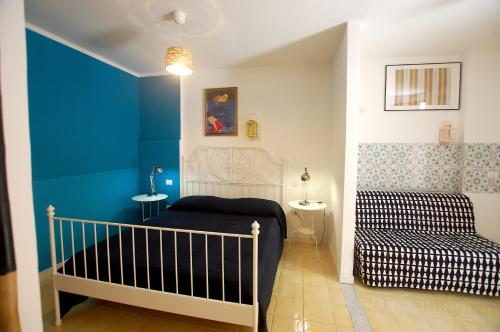 a bedroom with a crib and a blue wall at Appartamento Bouganville in Castellammare del Golfo