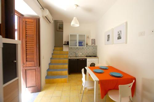 a kitchen and dining room with a table and chairs at Appartamento Bouganville in Castellammare del Golfo