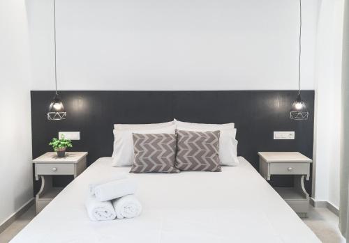een slaapkamer met een wit bed en 2 nachtkastjes bij Imeres Studios & Apartments in Polykhrono