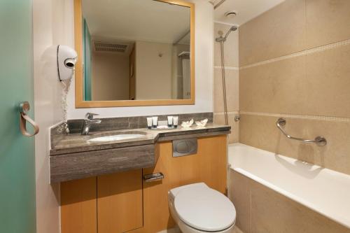 a bathroom with a sink and a toilet and a tub at Central Hotel in Athens
