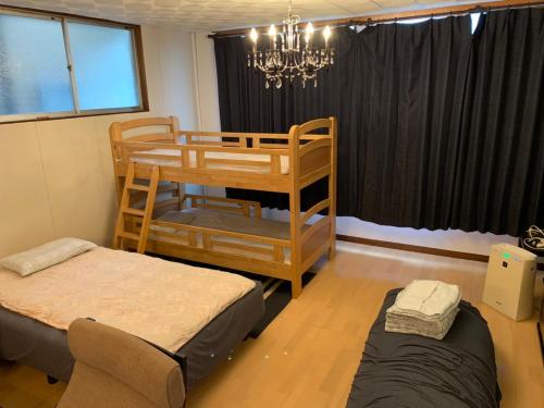 a bedroom with two bunk beds and a chandelier at hanare in Shingū