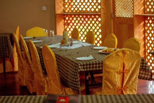 a dining room with a table with yellow chairs at New Charity Hotel International in Arusha