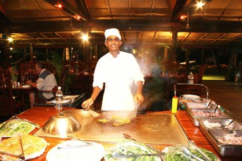 a chef standing in a kitchen preparing food at Club Fiji Resort in Nadi