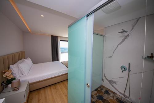 a bathroom with a shower and a bed at El Primero Hotel in Sarandë