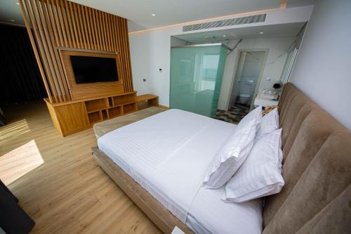 a bedroom with a large bed and a television at El Primero Hotel in Sarandë