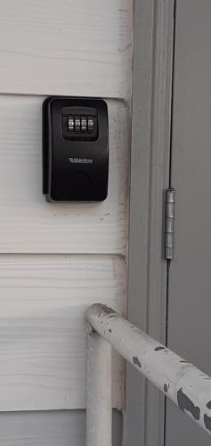 un botón en el costado de una puerta al lado de un poste en "Tom" Chez Tom et Dilou, en Kumak
