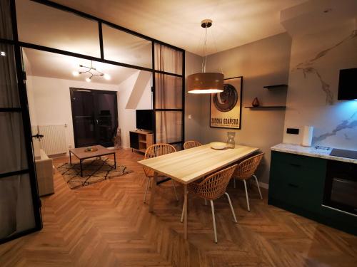 a kitchen and dining room with a wooden table and chairs at Trident Apartment III in Gdańsk