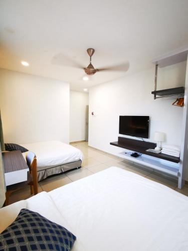 a bedroom with two beds and a flat screen tv at Secret Garden Warni Villa (MUAR) in Muar