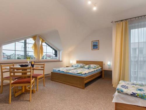 a bedroom with a bed and a table and a window at Pokoje Gościnne Alicja in Władysławowo