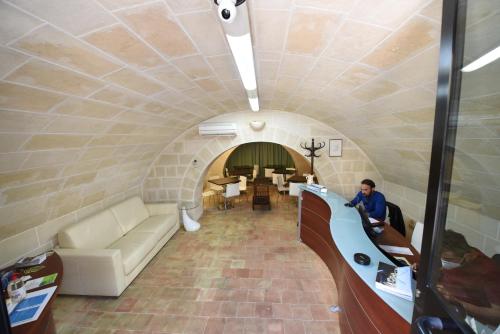 a man sitting on a couch in a tunnel at Dimore Le Lucane in Matera