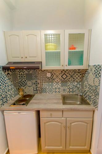 a kitchen with white cabinets and a sink at Kapetanios Luxury in Agios Georgios