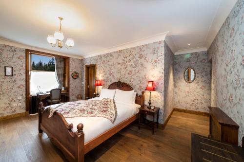 a bedroom with a bed and a desk and a window at Rokeby Manor in Invergarry