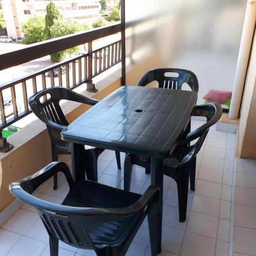 une table et deux chaises sur un balcon dans l'établissement Acapulco, à Fréjus