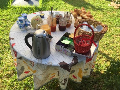 une table avec une bouilloire et des paniers de pain dans l'établissement la pergola, à Cavalaire-sur-Mer