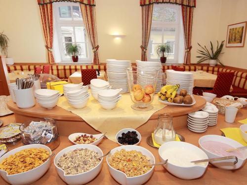 
a dining room table filled with dishes and bowls of food at Hotel Goldener Adler in Linz

