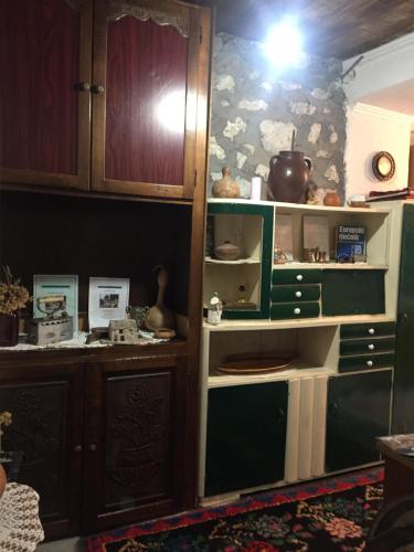 una cocina con armarios de madera y una estantería con platos en Etno House Stari mlin en Konjic