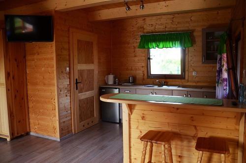 a kitchen with a counter in a wooden cabin at Słoneczna Dolina in Kąty Rybackie