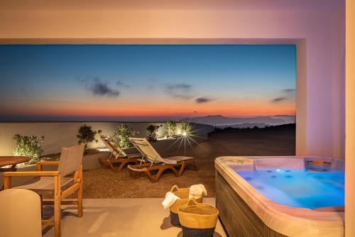 a room with a large window with a hot tub at Caldera Stories private suites in Megalochori